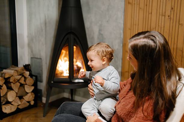istock Mother and toddler by the fireplace 2246303975