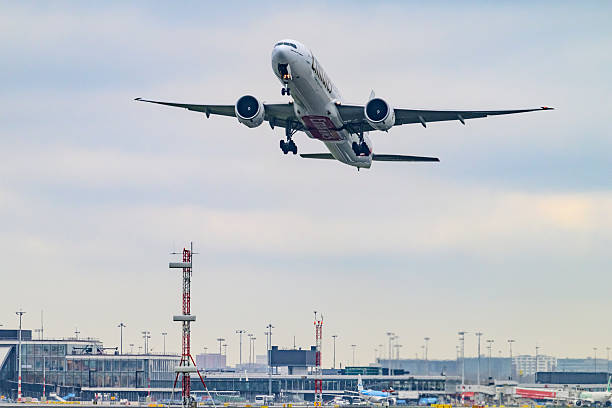 Emirates Airline Boeing 777-300ER taking off from Schiphol airport on the Kaagbaan during an overcast day at Amsterdam Schiphol airport in The Netherlands. Schiphol is one of the busiest and largest airports in Europe, located near Amsterdam, Netherlands. It serves as a major hub for international flights and is a key gateway to Europe.