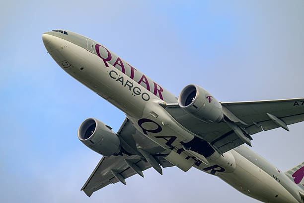 Qatar Airways Cargo Boeing 777F airplane taking off from Schiphol airport on the Kaagbaan during an overcast day at Amsterdam Schiphol airport in The Netherlands. Schiphol is one of the busiest and largest airports in Europe, located near Amsterdam, Netherlands. It serves as a major hub for international flights and is a key gateway to Europe.