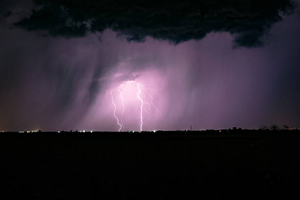 istock Dramatic night-time thunderstorm above the horizon with purple sky 2246304381