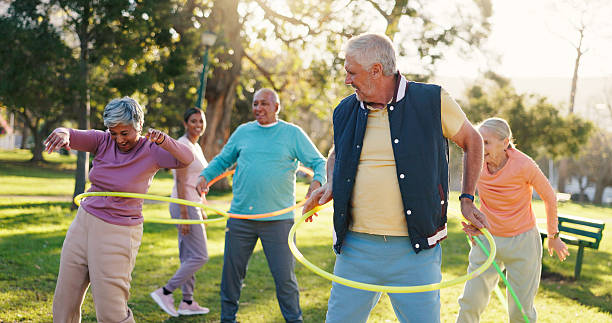 istock Senior people, class and exercise with hoop at park for active retirement, wellness or laugh. Elderly friends, ring and fitness outdoor, funny joke or workout for balance with group for cardio health 2246307482