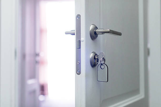 istock Door partially open with key inserted, welcoming light from hallway in home setting 2246307875