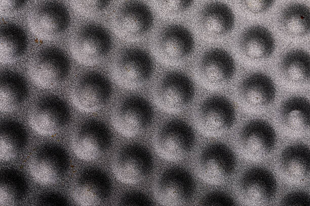 Close-up of a gray surface featuring repeating circular indents, ideal for backgrounds, design, and industrial concepts.