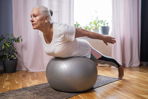 istock Middle aged woman in plank position keeps fit in her home 2246312182