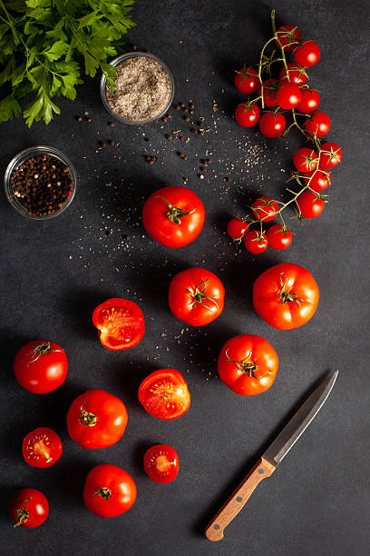 istock Fresh Tomatoes with Herbs, Salt, and Pepper on Dark Background 2246314768