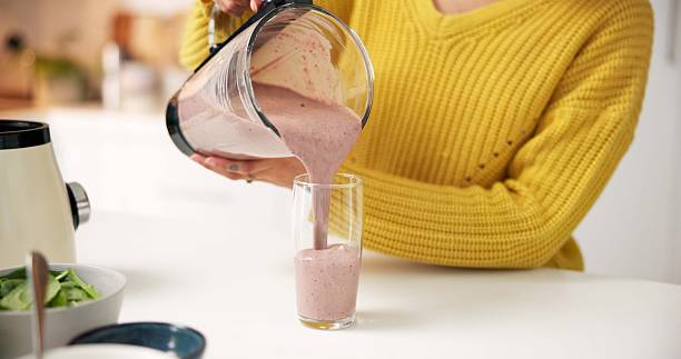 istock Pouring, smoothie and hands with blender, kitchen and healthy drink for nutrition boost and protein. Vegetarian, wellness and person with liquid for gut health benefits, home and detox with beverage 2246315314