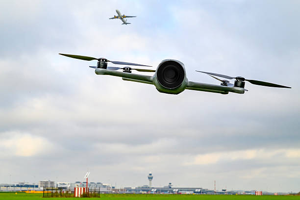 Drone flying close to Schiphol airport in The Netherlands. Incidents involving drones (unmanned aerial vehicles, UAVs) at or near airports have become a growing safety and security concern worldwide. These events typically involve drones being flown—intentionally or accidentally—into restricted airspace, disrupting commercial aviation and posing risks to aircraft and passengers.  Disclaimer: no drone rules were violated for this photo. The drone is hanging on a tripod with nylon wires and turned off.