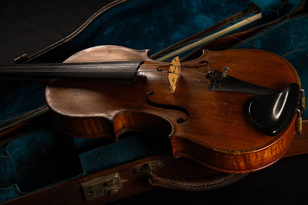 istock An old violin resting on a beautiful antique blue-green case. 2246319002