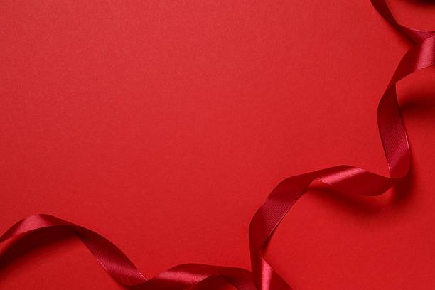 istock Festive red silk ribbon on color background 2246319194