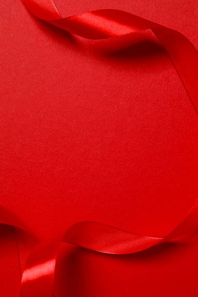 istock Beautiful red silk ribbon on color background, space for text 2246319334