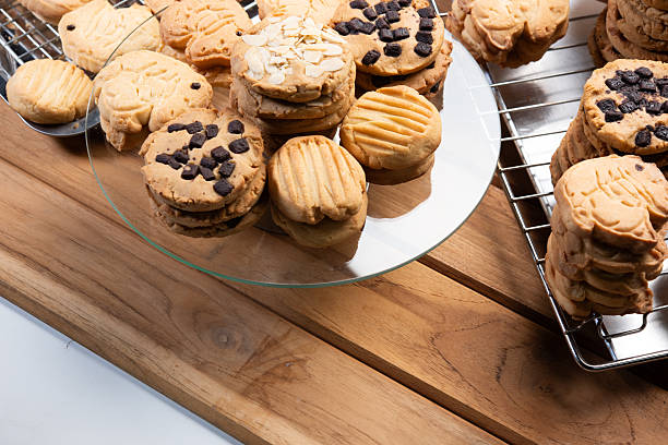 istock Fresh cookie stack with chips on glass plate, buttery shortbread chocolate sandwich dessert on wooden table cooling rack, golden baked treat with crumb texture and cozy mood 2246319366
