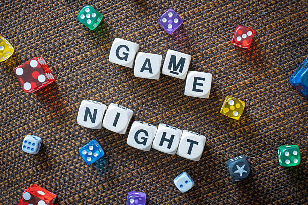 GAME NIGHT spelt using wooden word dice over a brown table cloth.