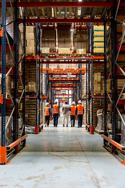 istock Workers walking through logistics warehouse with shelves of products 2246324293