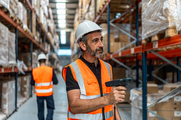 istock Warehouse worker wearing safety vest scanning inventory 2246324375