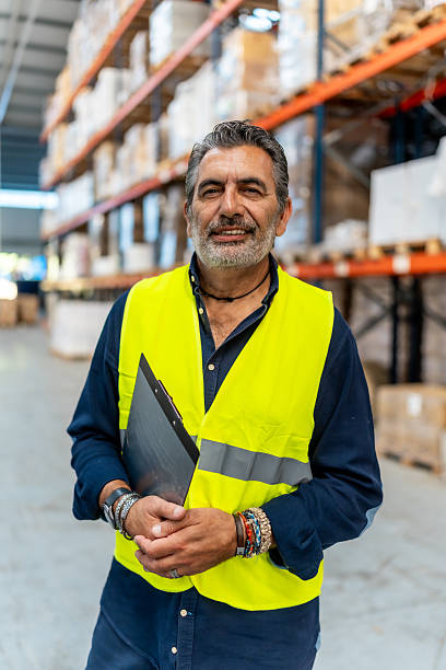 istock Mature adult man working in logistics warehouse smiling 2246324409