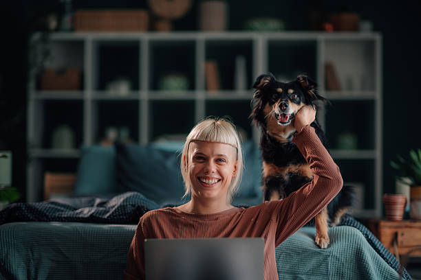 istock Woman working on laptop with a happy dog 2246327865