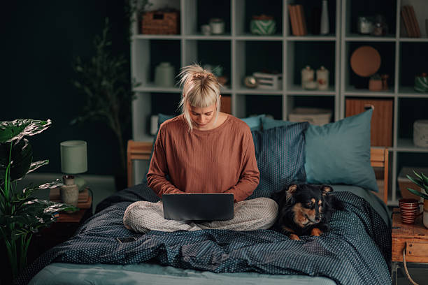 istock Woman working from home with dog on bed 2246327898