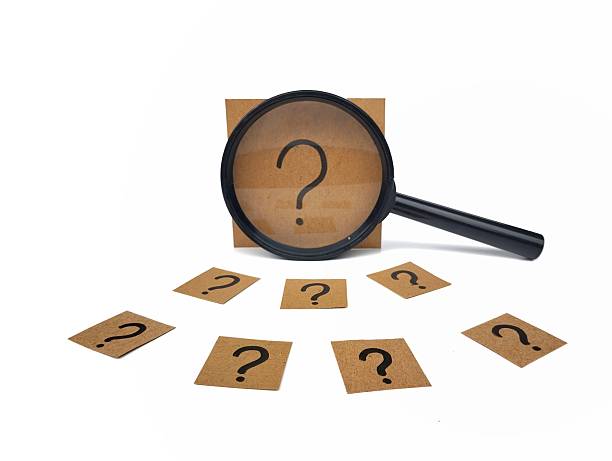 istock Question mark sign hand written on brown paper with magnifying glass on white background. 2246329848