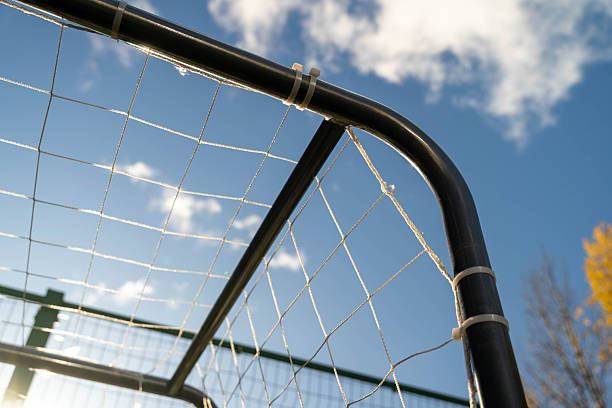 istock Soccer goal frame with netting against a bright blue sky, showcasing the structure and design of sports equipment, ideal for athletic and outdoor themes 2246330447