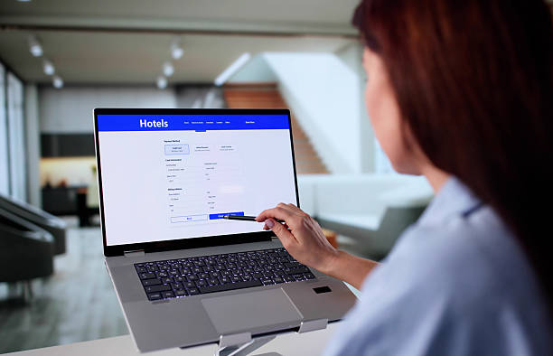 istock Woman Plans Hotel Stay Online Using Laptop 2246330759
