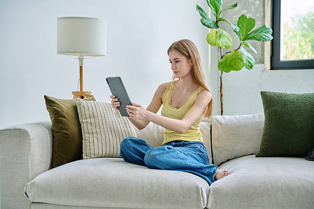 istock Young woman using digital tablet for video call, online chat conference sitting at home 2246332300