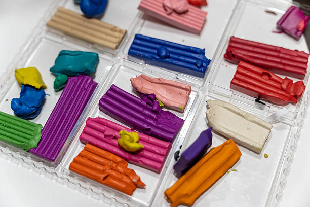 Colorful modeling clay pieces arranged in a clear plastic container, showcasing various vibrant hues and textures, ideal for creative projects and artistic endeavors