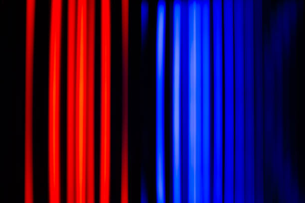 Abstract background of vertical neon light lines in contrasting red and blue colors, creating a vibrant, dynamic, and blurred effect.