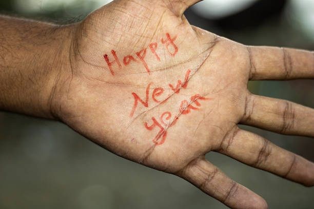 istock Hand with happy new year written in red ink on palm 2246338202