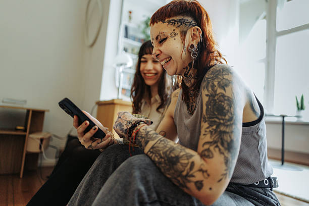 istock Two female friends using phone while sitting on floor at home 2246338360