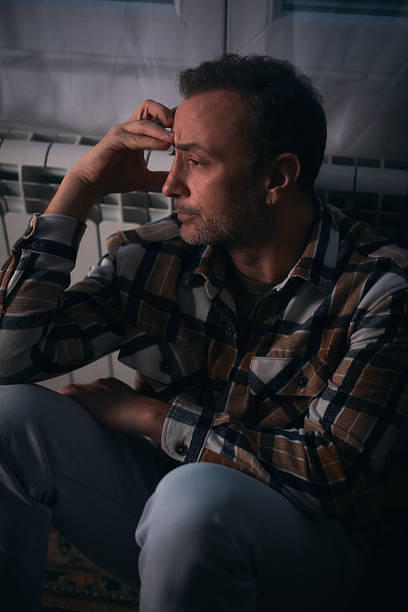 istock Man with depression and headache sitting on a chair at home. 2246340061