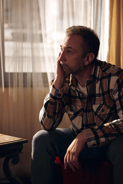 istock Man with depression and headache sitting on a chair at home. 2246340093