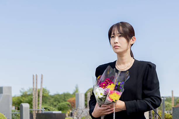 istock Asian woman visiting a grave 2246340558