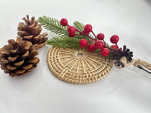 istock Decorative arrangement with pinecones, berry branches, and a wicker mat showcasing natural elements in a minimalistic setting for seasonal decor 2246342616