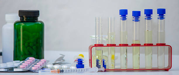 istock Microscope, medicine bottles, and magnifying glass on a white table for medical research 2246342977