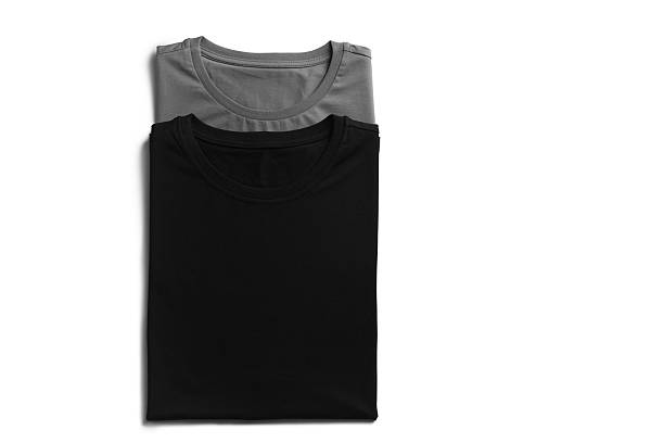 Black and grey t-shirts on white background, top view. Mockup for design