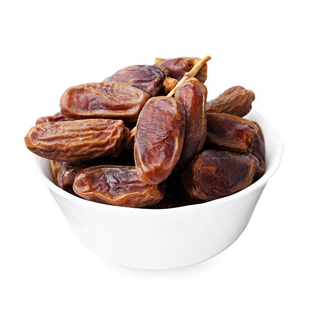 istock Tasty dried dates in bowl isolated on white 2246343967