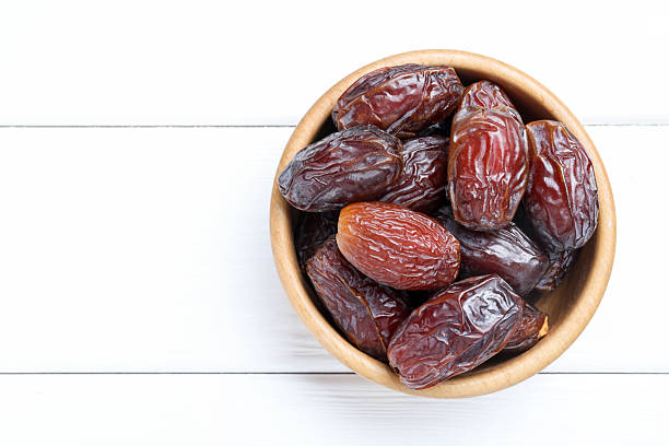 istock Tasty dried dates on white wooden table, top view. Space for text 2246344528