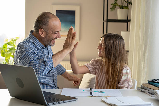 istock Father daughter learning homework together celebrating success with a high five 2246345339
