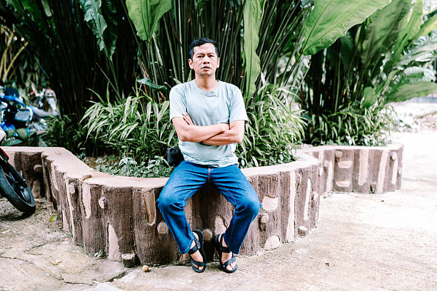 istock Casual Young Man Sits Relaxed Amidst Tropical Greenery 2246345958