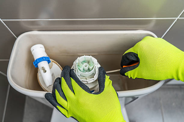 istock lumber fixing a toilet bowl 2246345962