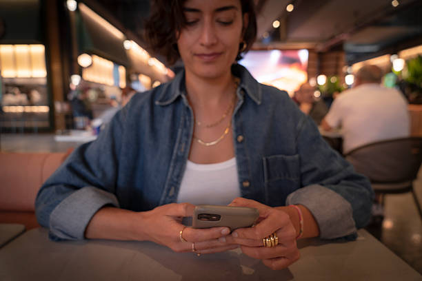 istock Woman using her smart phone at a cafe 2246347166