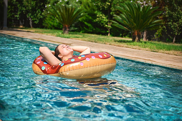 istock young woman relaxes and has fun in the pool 2246347718
