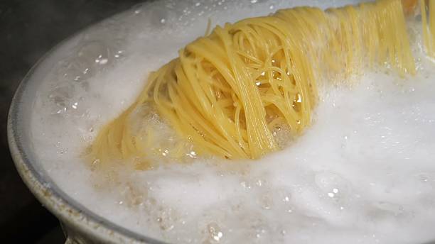 istock Boiling spaghetti noodles actively submerged in foamy white water 2246350514