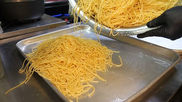 istock Draining a large volume of cooked spaghetti onto metal trays 2246350530