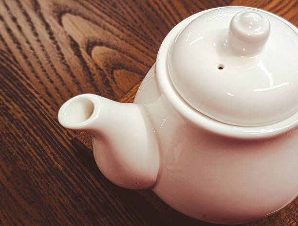 istock close up of a white ceramic teapot on a dark rustic wooden table background 2246350831