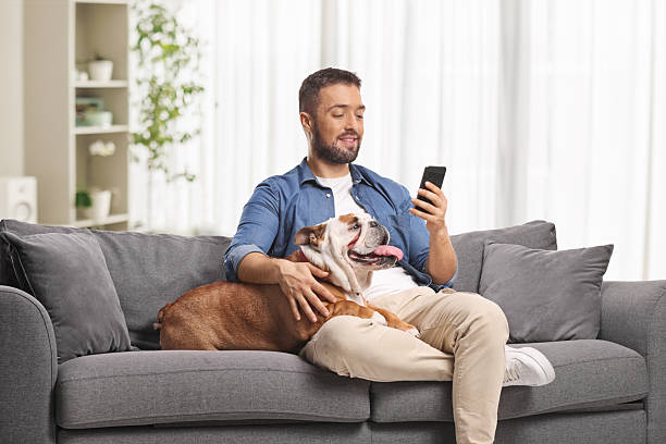 istock Young man resting on a sofa with his dog 2246355491