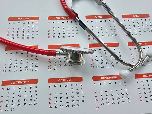 Stethoscope resting on a calendar with marked dates indicating health appointments concept