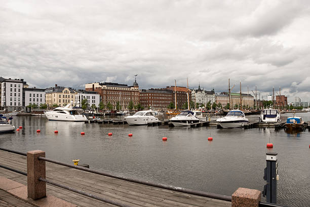 Helsinki, Finland - June 21, 2015 - Cloudy day at helsinki marina with boats and historic architecture.