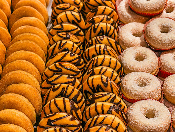 Close-up of sweet donuts on display shelf for sale at a bakery store.