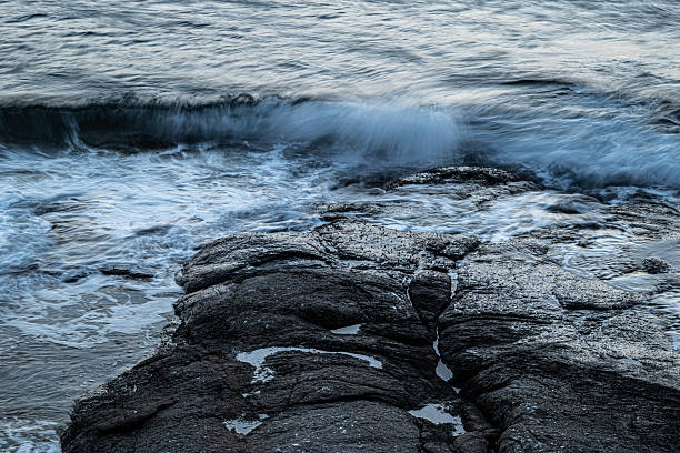 istock Waves Crashing on Rocky Shore at Dusk 2246363729